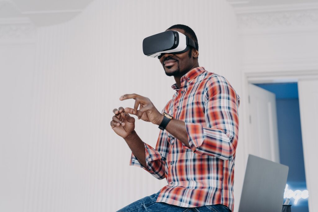 Modern african american man in virtual reality glasses enjoying virtual tour in augmented cyberspace
